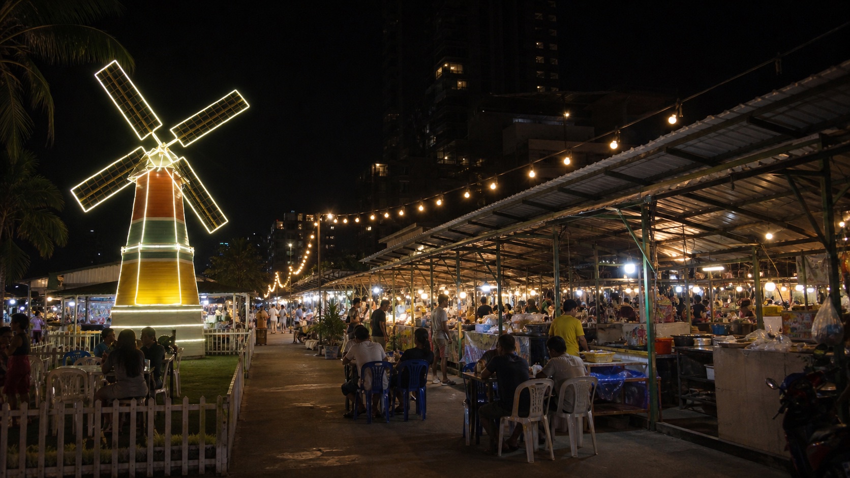 บรรยากาศตลาดกลางคืนจอมเทียน มีแผงอาหารและกังหันลมไฟ